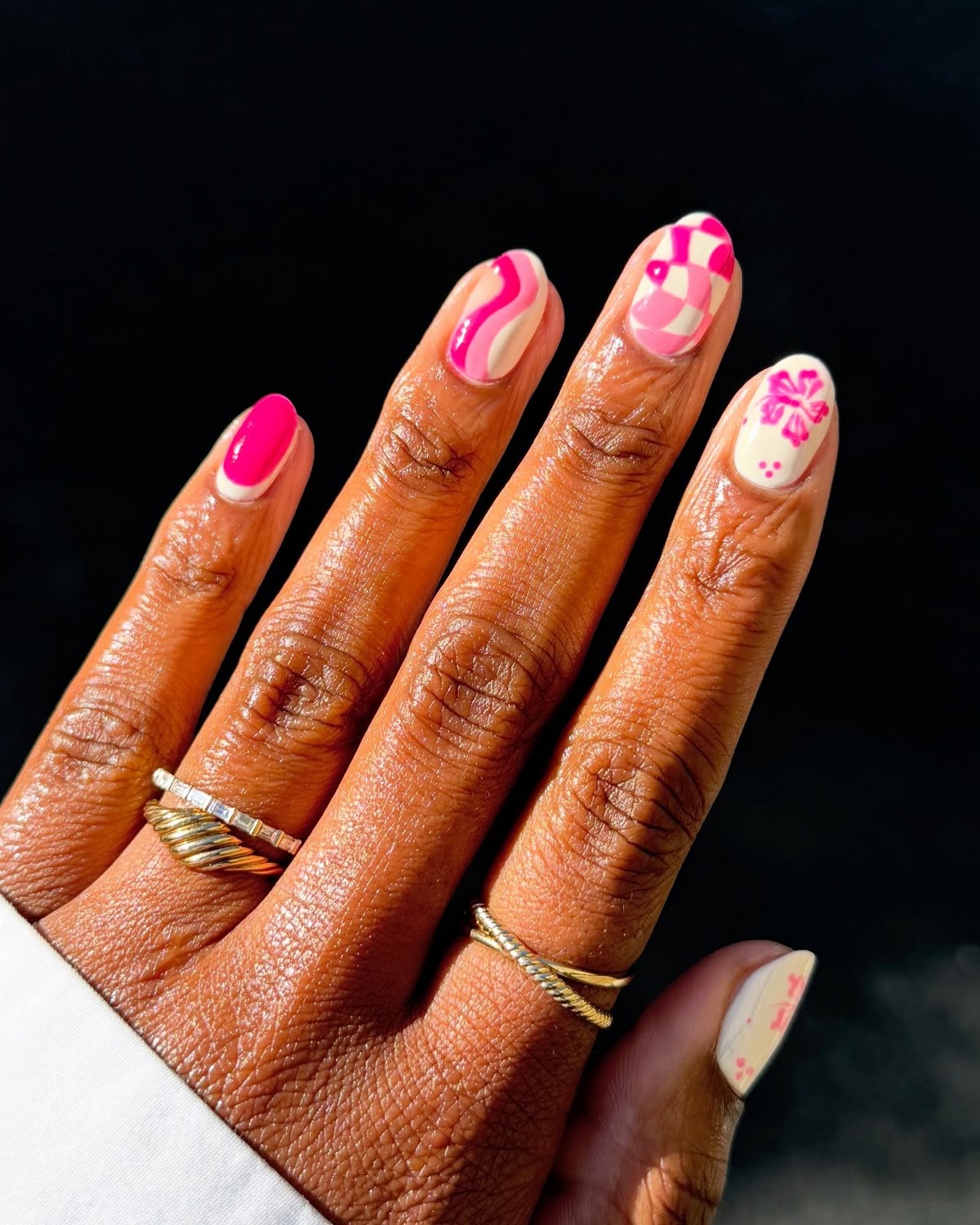 Рожевий nail-art і тонкі золоті каблучки створюють яскравий літній акцент